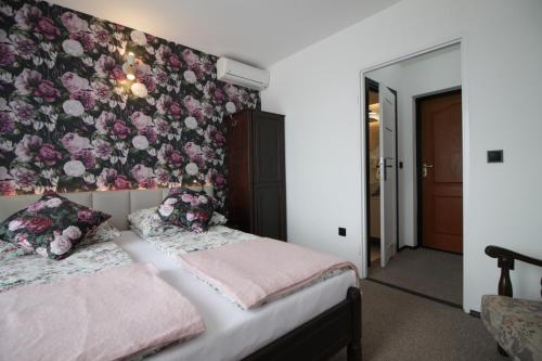 a bedroom with two beds and a floral wall at Motel Na Zbójeckiej in Skawa