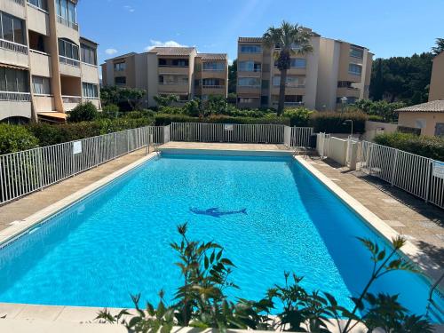 une piscine devant certains immeubles d'habitation dans l'établissement La perle des Estivales, STUDIO avec coin nuit enfants, parking et piscine , à 20min à pied port et plage, à Sanary-sur-Mer