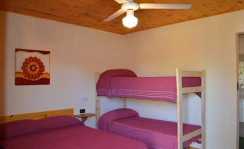 ein Schlafzimmer mit lila Etagenbetten und einer Decke in der Unterkunft Complejo Rancho Aparte in Villa Rumipal