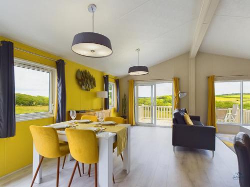 a dining room with yellow walls and a table and chairs at 7 Medina Rise Family fun for all in Porchfield