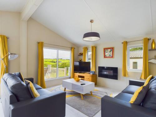 a living room with two blue couches and a tv at 7 Medina Rise Family fun for all in Porchfield