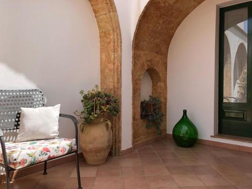 una habitación con una silla, un jarrón y una puerta en Lo Studio - Camilla's Guesthouse, en Morciano di Leuca
