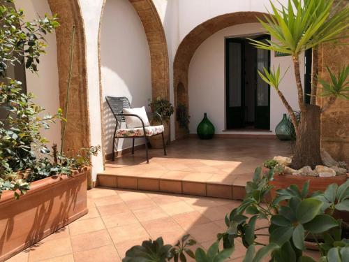 un patio interior con una silla y macetas en Lo Studio - Camilla's Guesthouse, en Morciano di Leuca
