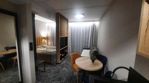 Habitación con sofá, mesa y cama en Złoty Horyzont Apartament Spa Szklarska Poręba, en Szklarska Poręba