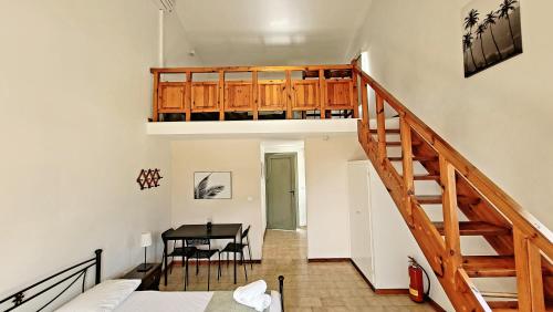 a room with a staircase and a table with chairs at Rodi Studios in Karavadhos