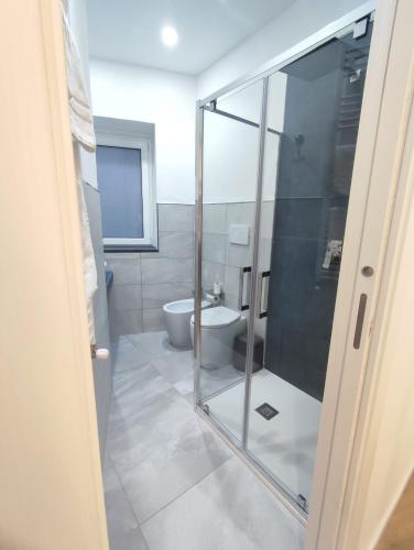 a bathroom with a glass shower and a toilet at La Zagara in Favara