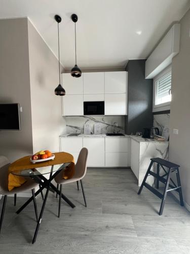 a kitchen with white cabinets and a table and chairs at Mia house a 7 minuti dalla metro in Pioltello
