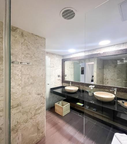 a bathroom with two sinks and a glass shower at B-Rent Atlantic Garden 181 in Corralejo