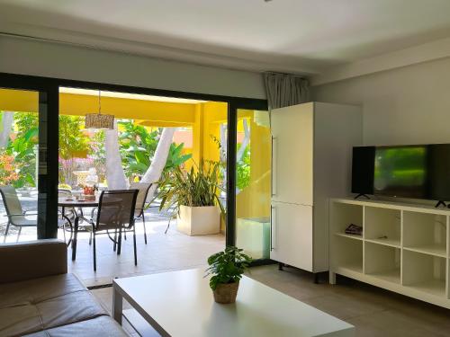 ein Wohnzimmer mit Fernseher und Tisch in der Unterkunft B-Rent Atlantic Garden 181 in Corralejo