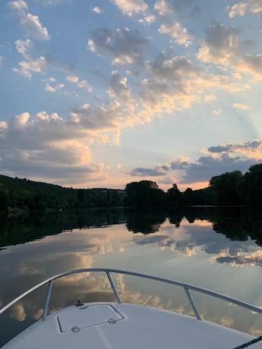 a boat on a river with a cloudy sky at Le Duo Porte-Joyeux in Porte-Joie