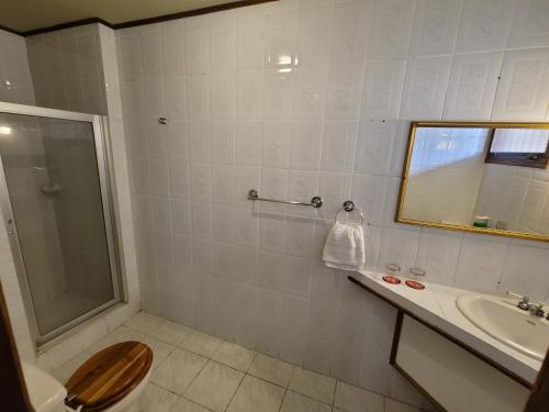 y baño con aseo, lavabo y espejo. en Pura Vida Dream en San José