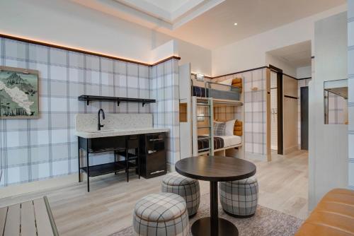 a kitchen and living room with a sink and a table at Moxy Banff in Banff