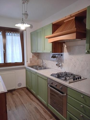 a kitchen with green cabinets and a stove at Andalo, Residence al Girasole FamPedron in Andalo