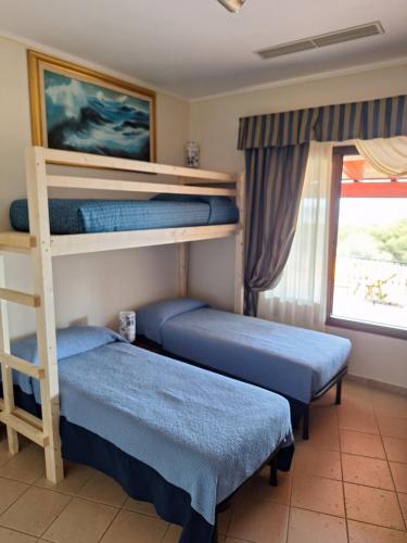 2 Etagenbetten in einem Zimmer mit Fenster in der Unterkunft Villa Caldinelli in Muravera