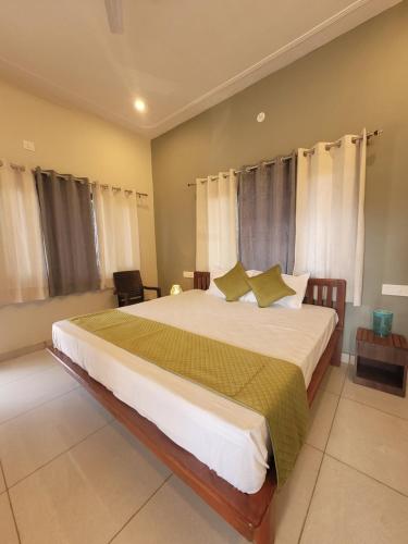 a bedroom with a large white bed with green pillows at 11 Gaon Homestay Lansdowne in Lansdowne