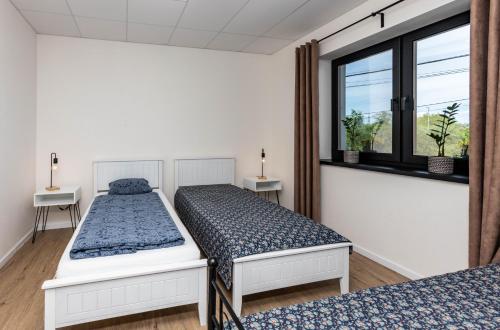 twee bedden in een kamer met een raam bij Sunny Apartment With Free Parking in Zvolen