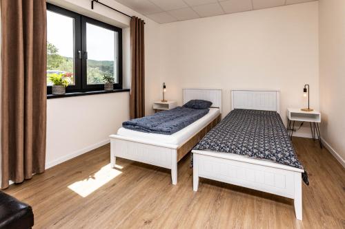 een slaapkamer met 2 bedden en een raam bij Sunny Apartment With Free Parking in Zvolen