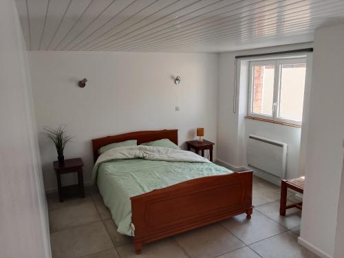 ein Schlafzimmer mit einem Bett in einem weißen Zimmer in der Unterkunft Poisson in Isigny-sur-Mer