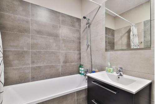 a bathroom with a sink and a tub and a shower at Airport Apartament Bokserska in Warsaw