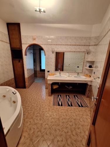 ein großes Bad mit einer Badewanne und einem Waschbecken in der Unterkunft Villa Caldinelli in Muravera
