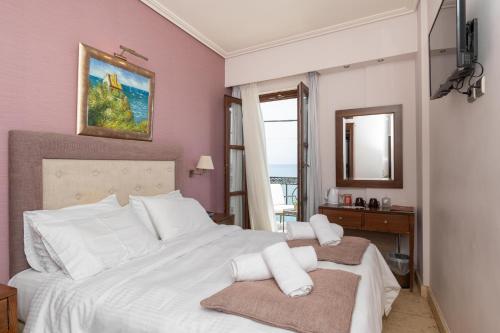 a bedroom with a large white bed with white pillows at La Boheme Hotel in Gythio