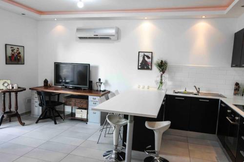 a kitchen with a table and a tv and a counter at Central cozy apt in quiet area in Engomi in Nicosia