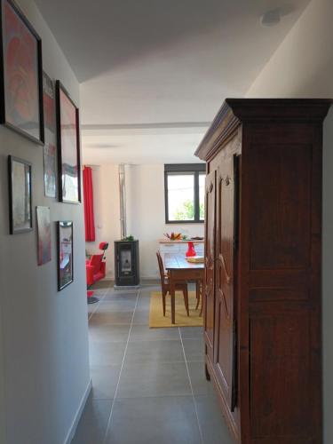 a living room with a table and a wooden cabinet at OUT a TIME in Angoville-sur-Ay