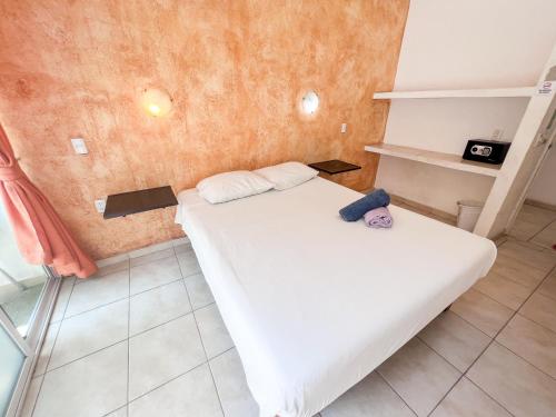 a small bedroom with a white bed in a room at ITH Sayulita Amazing Surf Hostel in Sayulita