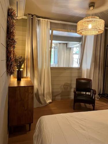 a bedroom with a bed and a chair and a window at Cosy Appartement Escapade Label Braise, terrasse et parking in Ségoufielle