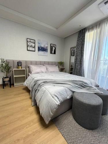 a bedroom with a large bed with a ottoman in it at Cozy Condo in Clark Pampanga with Free Parking & Pool Access in Mabalacat