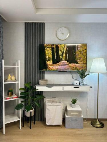 a living room with a tv on a wall at Cozy Condo in Clark Pampanga with Free Parking & Pool Access in Mabalacat