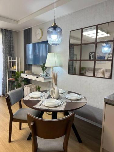 a dining room with a table and chairs and a mirror at Cozy Condo in Clark Pampanga with Free Parking & Pool Access in Mabalacat