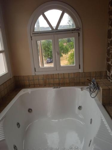 a bath tub in a bathroom with a window at Alegria house with gardens near portoheli in Kranidi