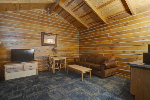 a living room with a couch and a tv at Rock Crest Lodge & Cabins in Custer