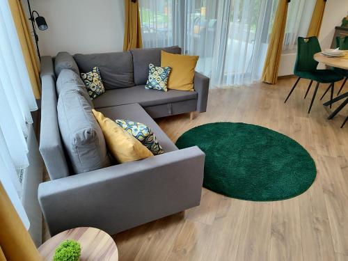 a living room with a couch and a green rug at MOHA Weekend in Bánk