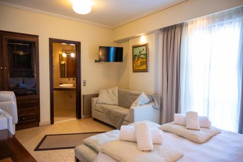 uma sala de estar com uma cama e um sofá em La Boheme Hotel em Gythio