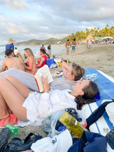 two women laying on the beach reading books at ITH Sayulita Amazing Surf Hostel in Sayulita