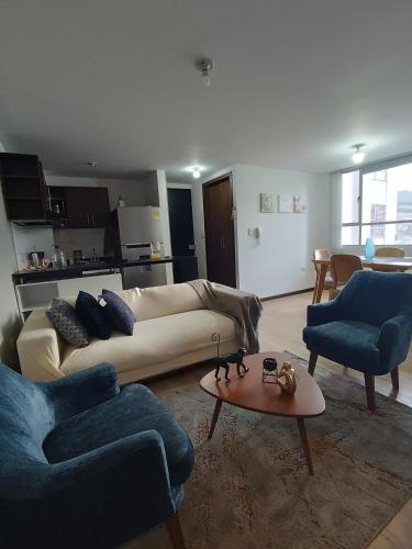 a living room with a couch and two chairs and a table at Cómodo apartamento central in Pasto