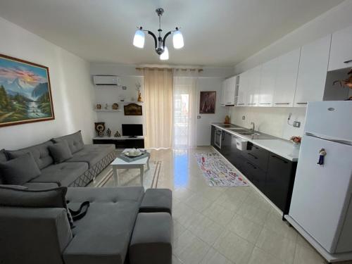 una cucina e un soggiorno con un divano e un frigorifero di Liam Apartments a Vlorë