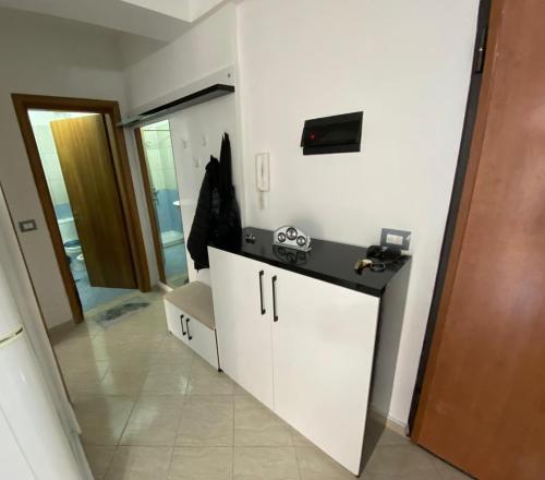 un bagno con un mobiletto bianco e uno specchio di Liam Apartments a Vlorë