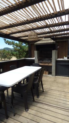 a table and chairs on a deck with an outdoor grill at Casalmar Pupuya in Pupuya