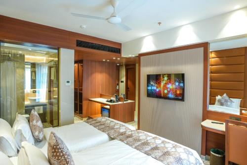 a bedroom with a bed and a tv on a wall at InstaFeel Hotel in Navi Mumbai