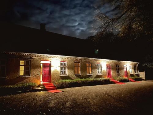 VeddelevにあるSvaleholm Gaard Roskildeの夜の赤いドアのレンガ造りの家