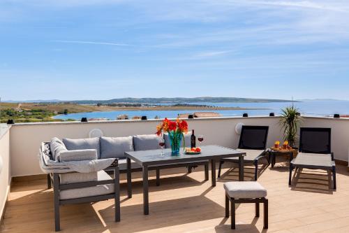 a patio with a table and chairs on a balcony at Terra Maiorum -12 person private Villa - heated pool and water massage in Povljana