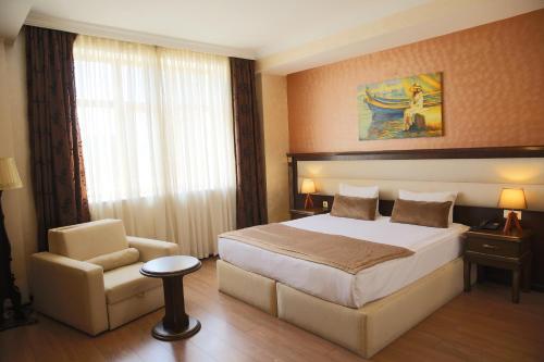 Habitación de hotel con cama y silla en Smith Hotel Baku en Baku