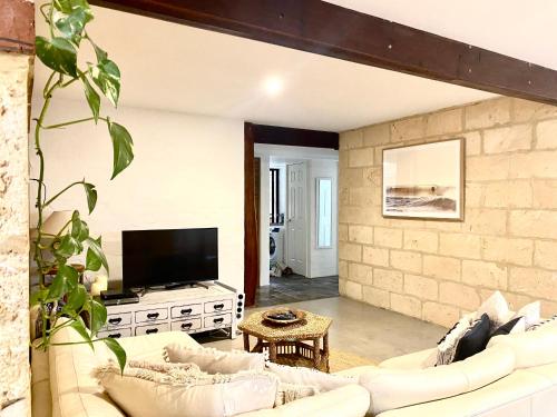 a living room with a white couch and a tv at By the Sea Margaret River in Gnarabup