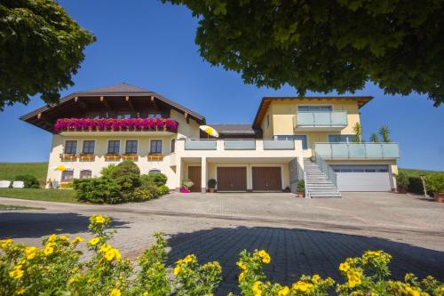 uma grande casa amarela com flores na frente em Gästehaus Stabauer em Mondsee