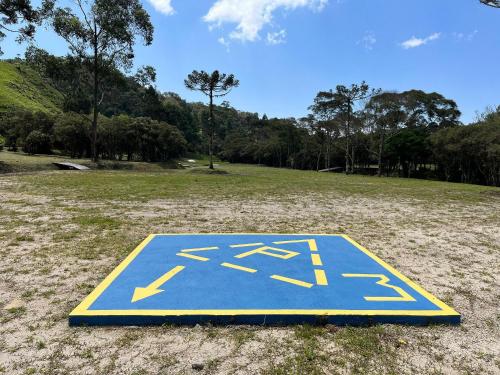 a blue and yellow sign in a field at Vila Vert - Rancho Queimado - SC in Rancho Queimado