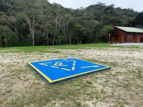 a blue sign on the ground in a field at Vila Vert - Rancho Queimado - SC in Rancho Queimado