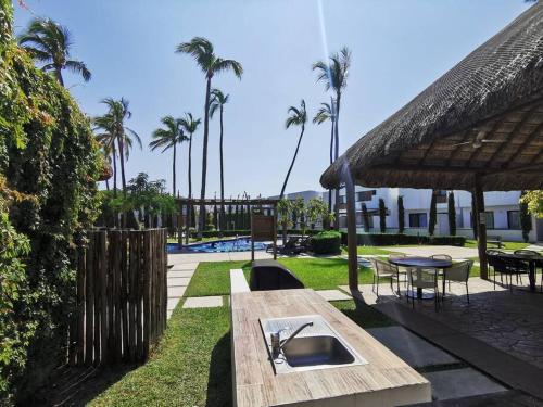 Una mesa de picnic en un complejo turístico con palmeras. en Tu casa en Mazatlán,, en La Florida